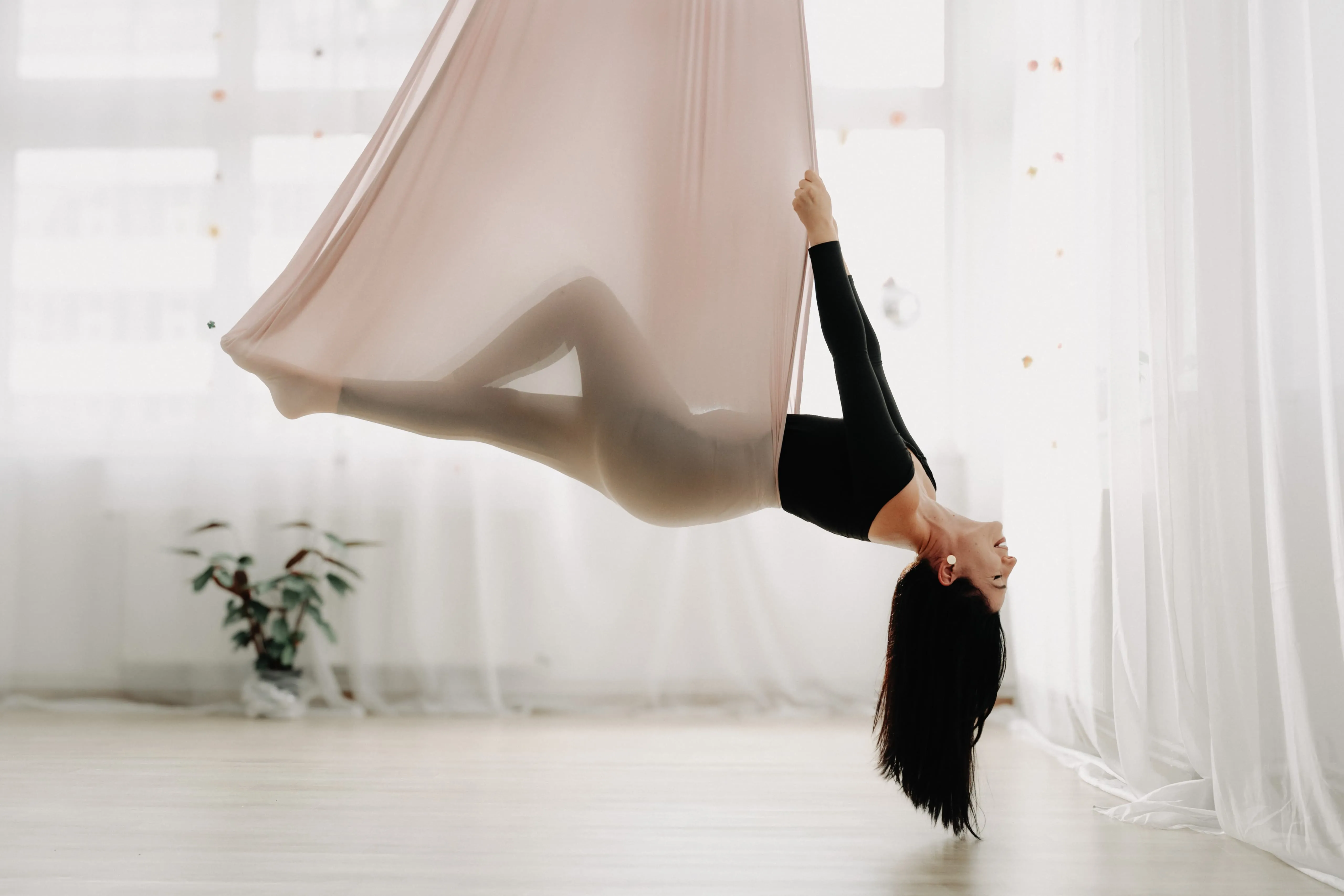 Clasă de Yin Aerial Yoga în Cluj-Napoca: corp susținut de hamac într-o sală cu lumină naturală